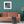 Margaux wallpaper by Tatie Lou in teal, marbled swirls behind a sofa in a living room