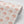Marigold wallpaper by Annika Reed in pink, partly unrolled roll showing marigold flowers
