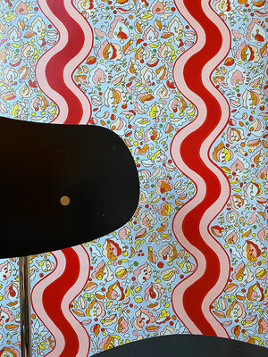 Melodie wallpaper by Claire de Quénetain in grey and red, wavy ribbon stripes in a styled room setting