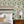 Midsummer wallpaper by Deus ex Gardenia in cream and blue, trailing bellflowers behind a bed