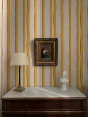 Somerset Stripes wallpaper by Annika Reed in yellow, painted stripes above a cabinet