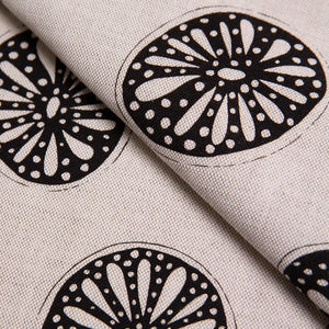 Opium linen by Bethie Tricks in black and white, draped, showing bold wheel motifs