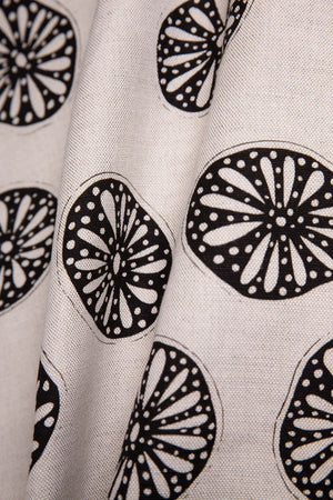 Opium linen by Bethie Tricks in black and white, full repeat of bold wheel motifs