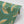 Pachamama wallpaper by Tatie Lou in green, partly unrolled roll showing flying cranes