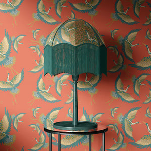 Pachamama vinyl wallpaper by Tatie Lou in coral, flying cranes above a sideboard