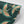 Pachamama wallpaper by Tatie Lou in dark green, partly unrolled roll showing flying cranes
