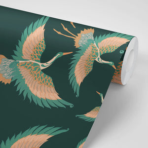 Pachamama wallpaper by Tatie Lou in dark green, partly unrolled roll showing flying cranes
