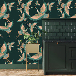 Pachamama wallpaper by Tatie Lou in dark green, flying cranes behind a console table