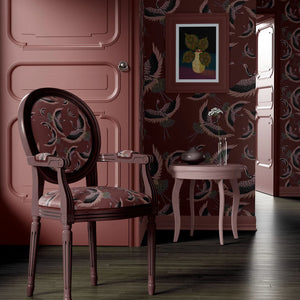 Pachamama wallpaper by Tatie Lou in burgundy, flying cranes behind a sofa in a living room