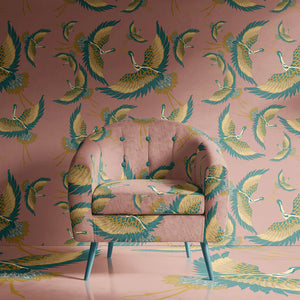 Pachamama wallpaper by Tatie Lou in pink and teal, flying cranes upholstered on an armchair