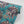Phoenix wallpaper by Tatie Lou in teal and pink, sample roll showing swirling phoenix feathers