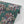Phoenix wallpaper by Tatie Lou in teal, roll showing swirling phoenix feathers