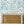 Pia wallpaper by Claire de Quénetain in light green, scattered leaves in a styled room setting
