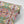 Franny wallpaper by Tatie Lou in pink and green, partly unrolled roll showing a kaleidoscopic floral