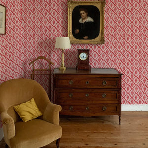 Jaipur wallpaper by Annika Reed in red, block-print medallions above a sideboard