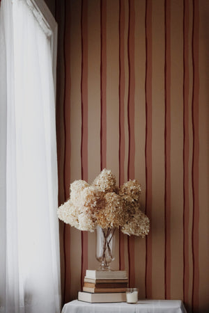 Somerset Stripes wallpaper by Annika Reed in red, painted stripes in a living room