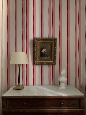Somerset Stripes wallpaper by Annika Reed in red, painted stripes above a sideboard