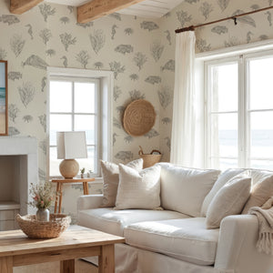 Solent Snapper wallpaper by XV Interiors in cream, fish, seahorses and coral behind a sofa in a living room