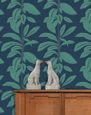 Rubber Plant wallpaper by Annika Reed in navy and green, rubber plant leaves above a sideboard