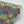 Hampi wallpaper by Tatie Lou in green, sample roll showing tropical flowers in a mirrored print