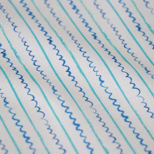 Sea Lines linen by Seed Home Designs in blue and white, in soft folds showing fine watercolour stripes