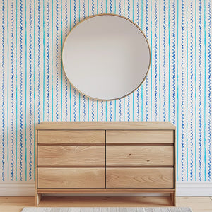 Sea Lines Stripe wallpaper by Seed Home Designs in blue and white, fine watercolour stripes above a sideboard