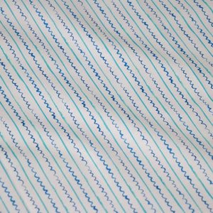 Sea Lines linen by Seed Home Designs in blue and white, draped close-up of fine watercolour stripes