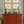 Stow Away With the Sailors wallpaper by Annika Reed in blue and red, sailors and boats above a sideboard