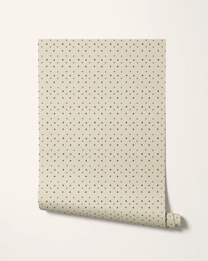 Suits You wallpaper by Annika Reed in cream and red, partly unrolled roll showing tiny card suits