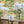 Tally Ho! wallpaper by Brand McKenzie in green and blue, a countryside landscape behind a dining table
