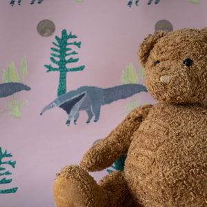 The Anteater wallpaper by Annika Reed in pink, anteaters and trees in a child's room