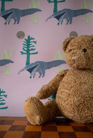 The Anteater wallpaper by Annika Reed in pink, anteaters and trees in a child's room