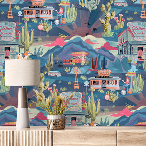 The Glitter Ranch wallpaper by Brand McKenzie in navy, a desert ranch scene above a sideboard
