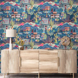 The Glitter Ranch wallpaper by Brand McKenzie in navy, a desert ranch scene behind a console table
