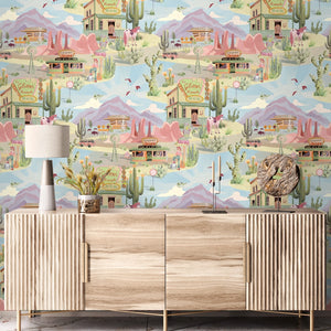 The Glitter Ranch wallpaper by Brand McKenzie in pink and blue, a desert ranch scene above a sideboard