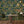 The Grand Pour wallpaper by Brand McKenzie in dark green, swimmers among cocktail glasses in a dining room