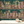 The Parlour wallpaper by Brand McKenzie in teal, close view of ladies under salon hair dryers