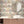 The Parlour wallpaper by Brand McKenzie in cream and pink, ladies under salon hair dryers in a bathroom setting