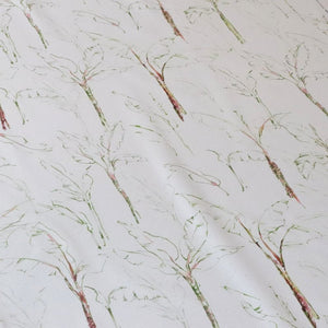 Tropical Paradise fabric by Seed Home Designs in green and beige, in soft folds showing slender tropical stems