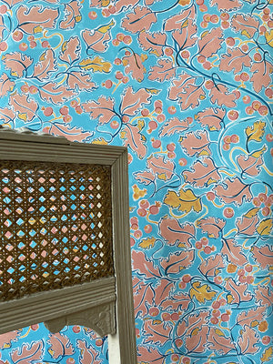 Veronique wallpaper by Claire de Quénetain in blue and pink, a hand-painted floral design in a styled room setting