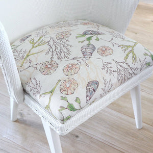 Coastal Cove fabric by Seed Home Designs in beige, line-drawn shells and seaweed upholstered on an armchair