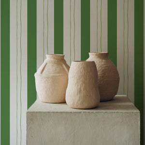 Wobble Large wallpaper by Annika Reed in green, wobbly stripes above a sideboard