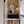 Resplendent Woods in India wallpaper by Deus ex Gardenia in yellow, parrots in tropical branches in a bathroom