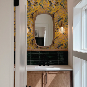 Resplendent Woods in India wallpaper by Deus ex Gardenia in yellow, parrots in tropical branches in a bathroom