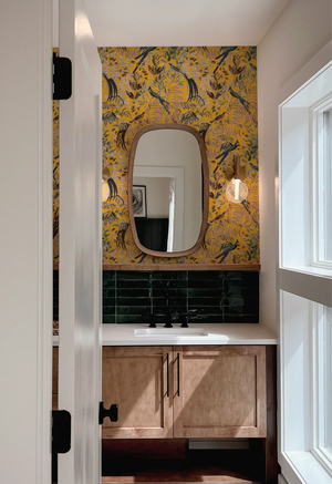 Resplendent Woods in India superwide wallpaper by Deus ex Gardenia in yellow, parrots in tropical branches in a bathroom